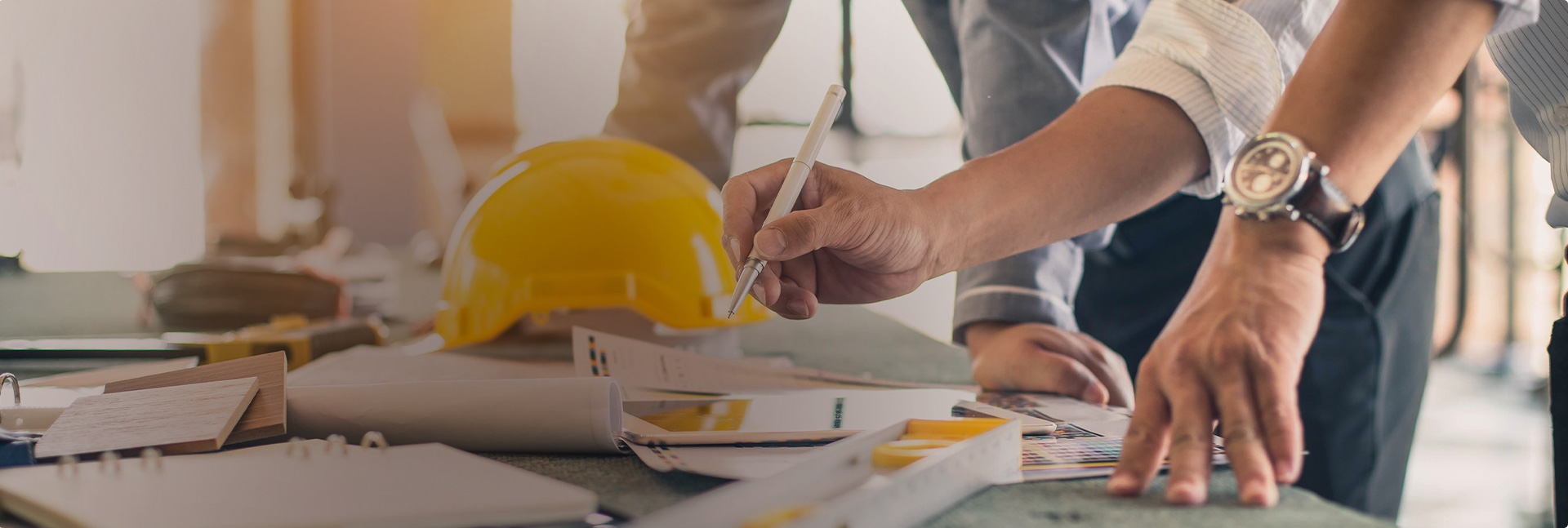 Closeup of contractor's hands working on home plans